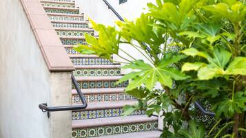 A staircase with colorful patterned tiles and a metal handrail.