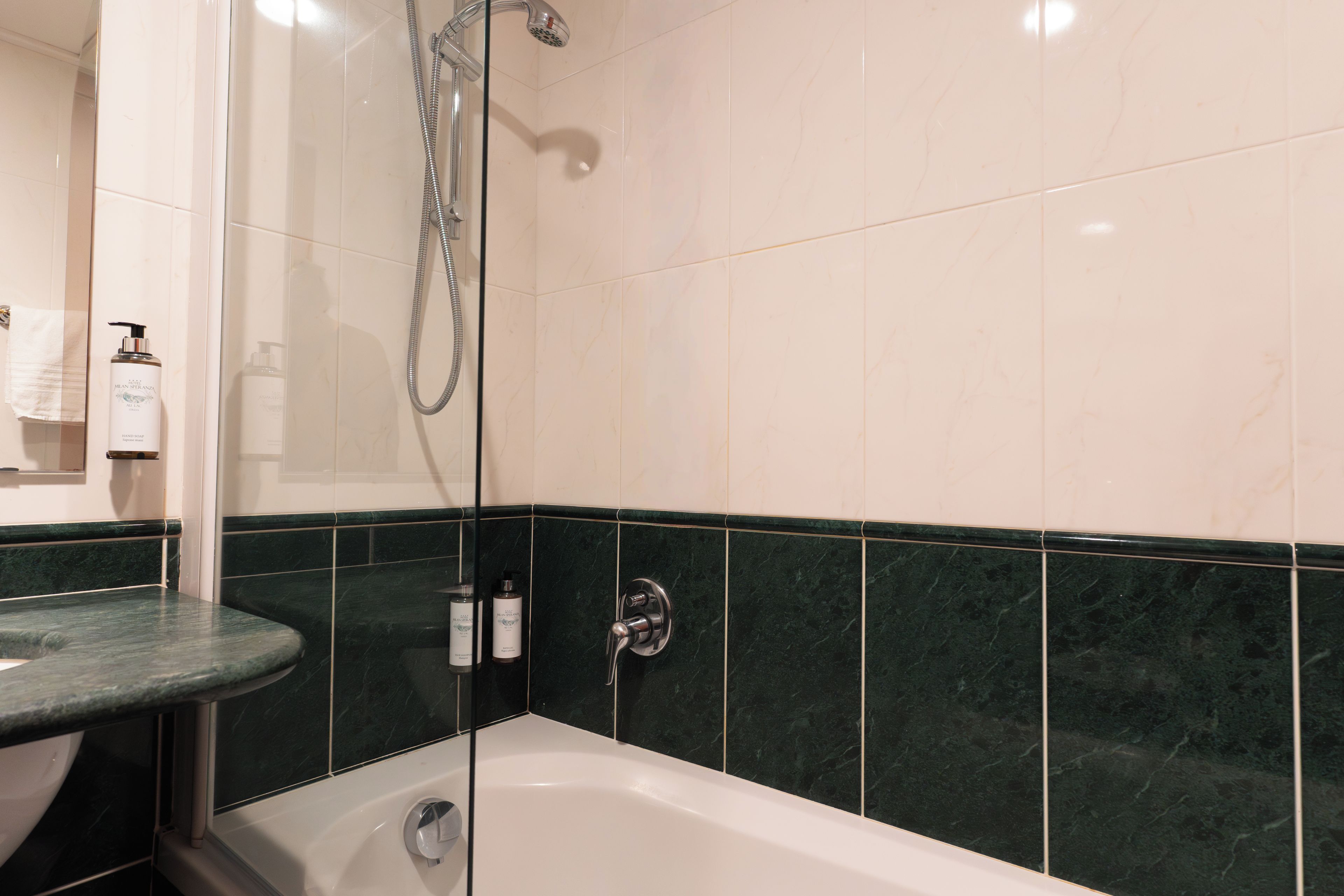 A bathroom with a bathtub, a shower, and a sink.