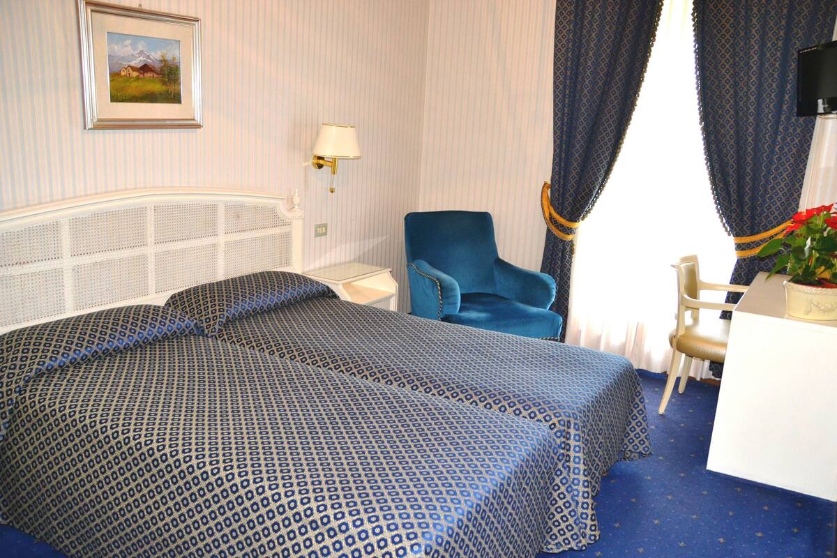 Une chambre d’hôtel équipée d’un lit, d’un bureau, d’une chaise et d’un téléviseur.