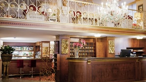 A lobby with a reception desk, bar area, and decorative iron railings. - Hotel Milan Speranza Au Lac (Stresa)
