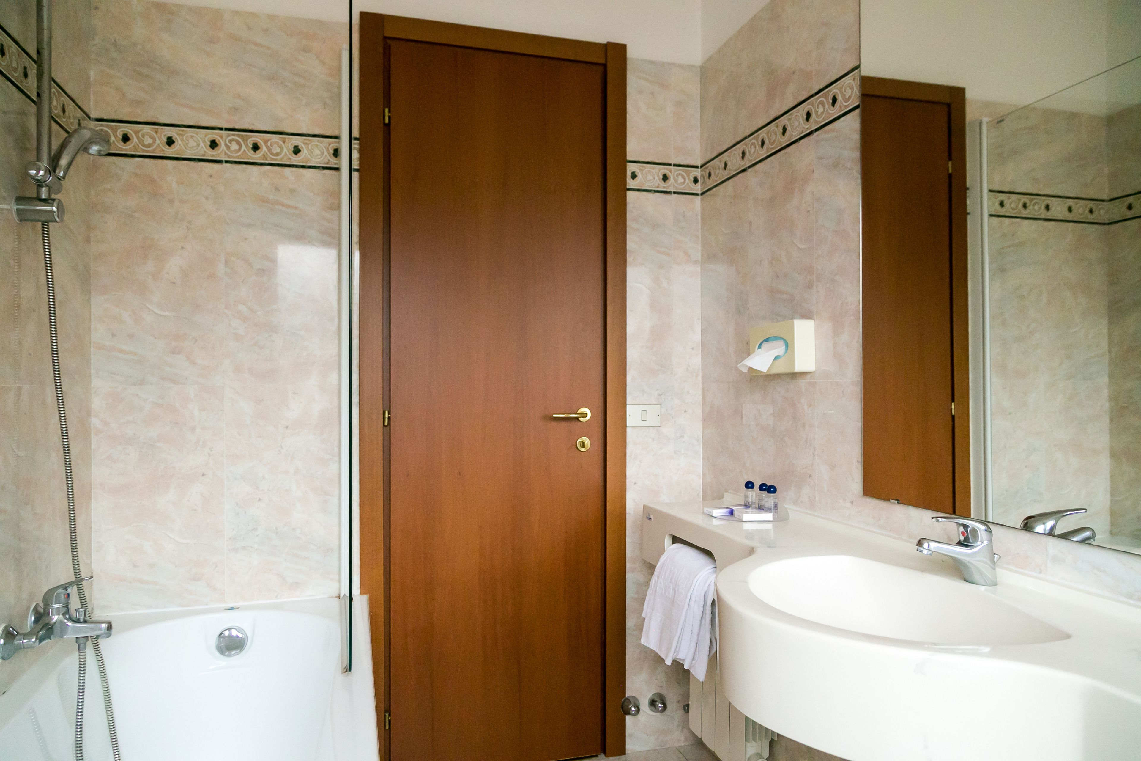 A bathroom with a bathtub, a sink, and a mirror.