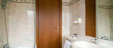 A bathroom with a bathtub, a sink, and a mirror.