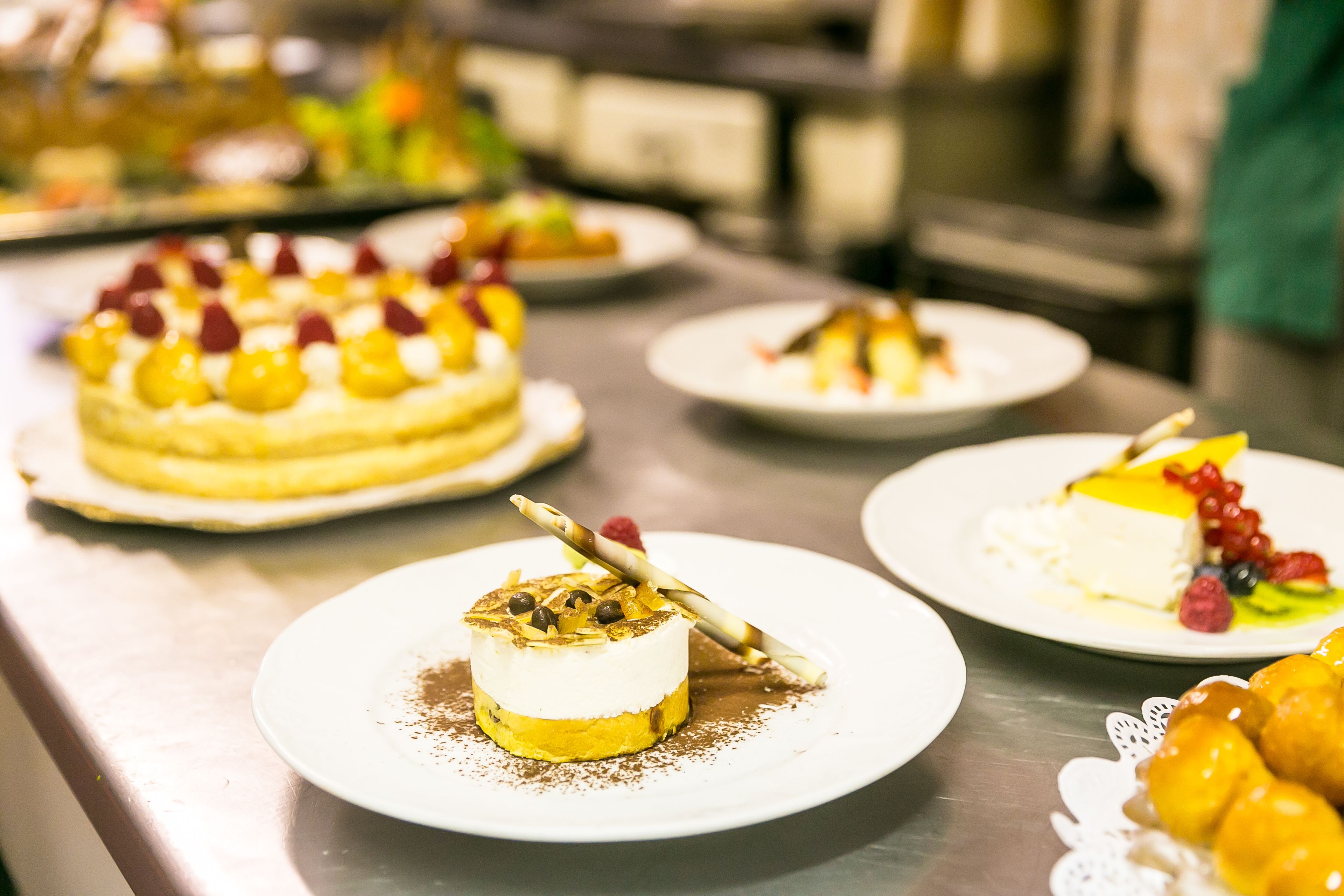 A variety of desserts on plates, including cakes and pastries, arranged on a table.