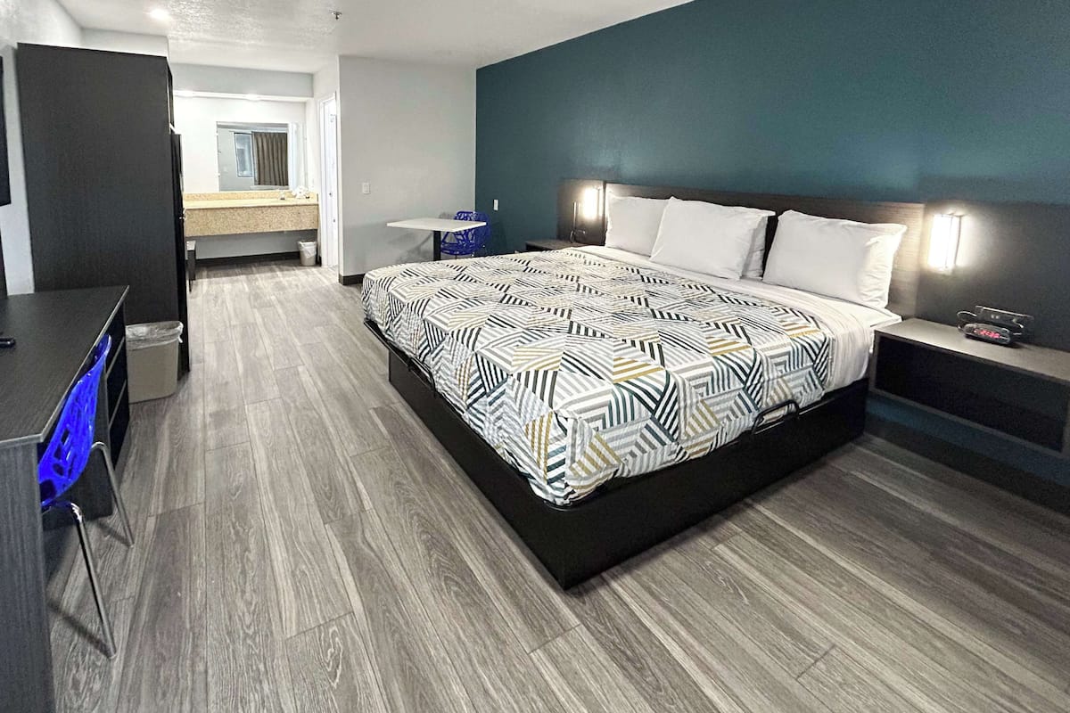 Une chambre d’hôtel moderne, dotée d’un grand lit, d’un bureau et d’une chaise.