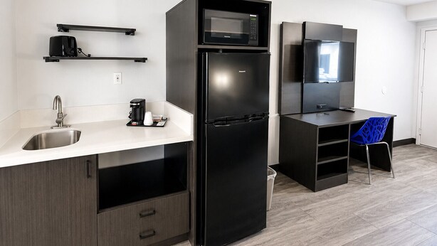 A modern kitchen with a built-in microwave, refrigerator, and coffee maker. - Value Stay Inn Extended Stay Bakersfield (Bakersfield)