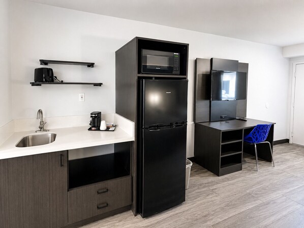 A modern kitchen with a built-in microwave, refrigerator, and coffee maker. - Value Stay Inn Extended Stay Bakersfield (Bakersfield)