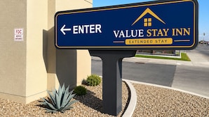 A sign for Value Stay Inn with an arrow pointing left for entry. - Value Stay Inn Extended Stay Bakersfield (Bakersfield)