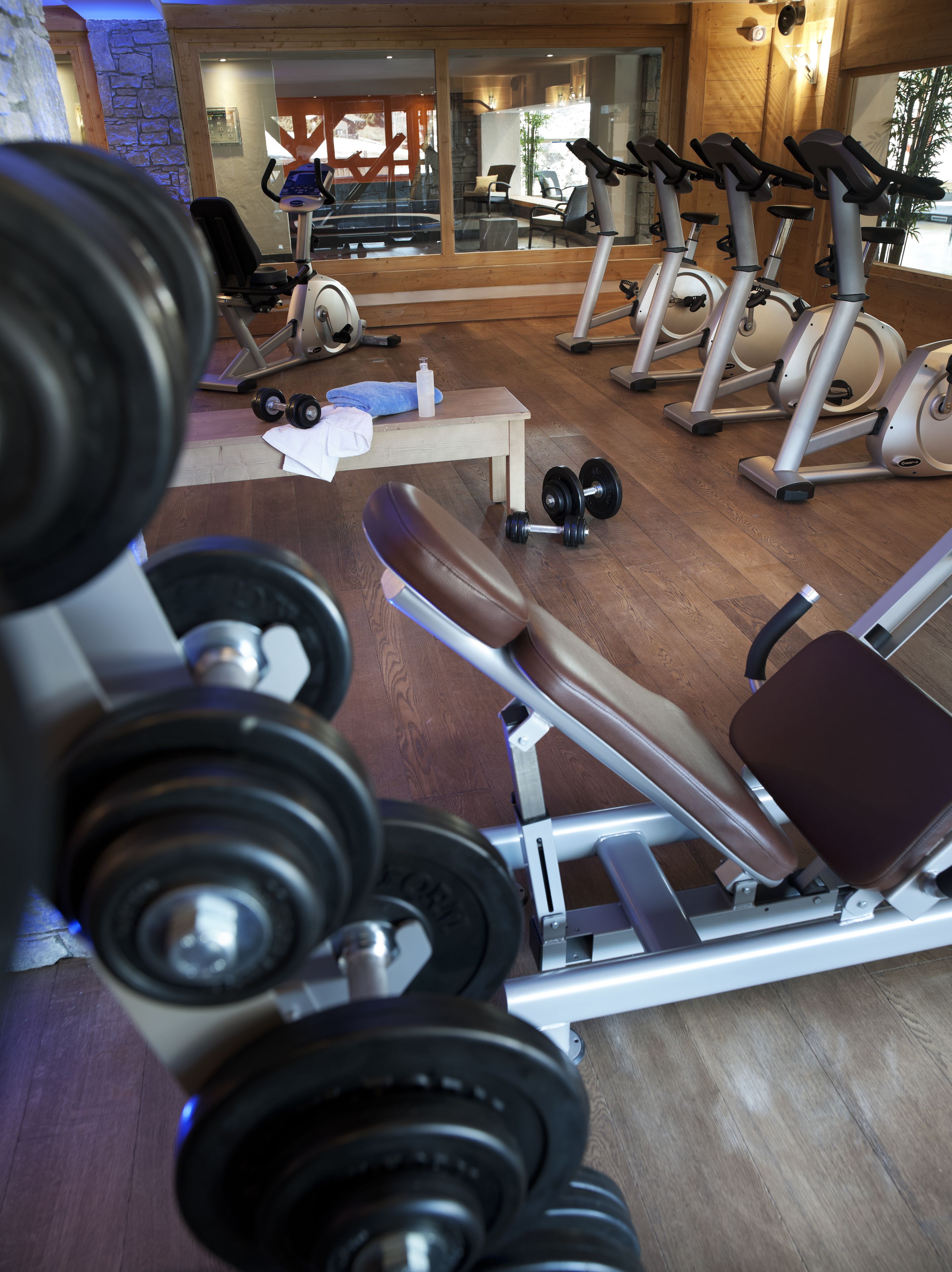 Ett gym med träningsredskap, en bänk och hantlar.