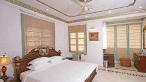 A well-lit bedroom with a large bed, a ceiling fan, and a window with a view. - Perfect Haven Egmore Serviced Apartments (Chennai)