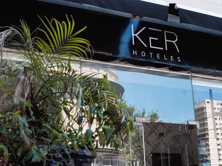 A hotel sign with the name 'KER HOTELS' and a modern building in the background.