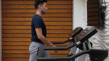Una persona usando una bicicleta estática en una habitación con paneles de madera.