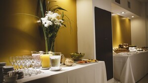 Een feestelijk gedekte tafel met borden, glazen, een karaf, een vaas met bloemen en een schaal fruit.