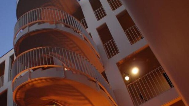 Un edificio de varios pisos con una escalera de caracol y balcones.