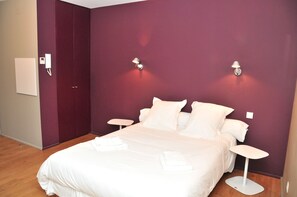 Relax in a serene space with a large bed, two bedside tables, and a small table.
