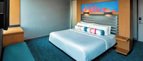 Een moderne hotelkamer met een groot bed, een stadsgezicht kunstwerk op het hoofdeinde, een flatscreen televisie en een houten nachtkastje.