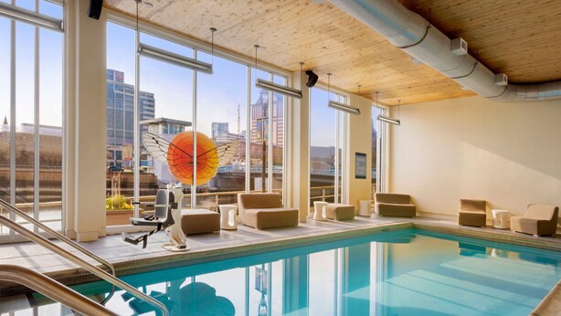 An indoor swimming pool with clear views of the city skyline through large windows. - Aloft by Marriott Milwaukee Downtown (Milwaukee)