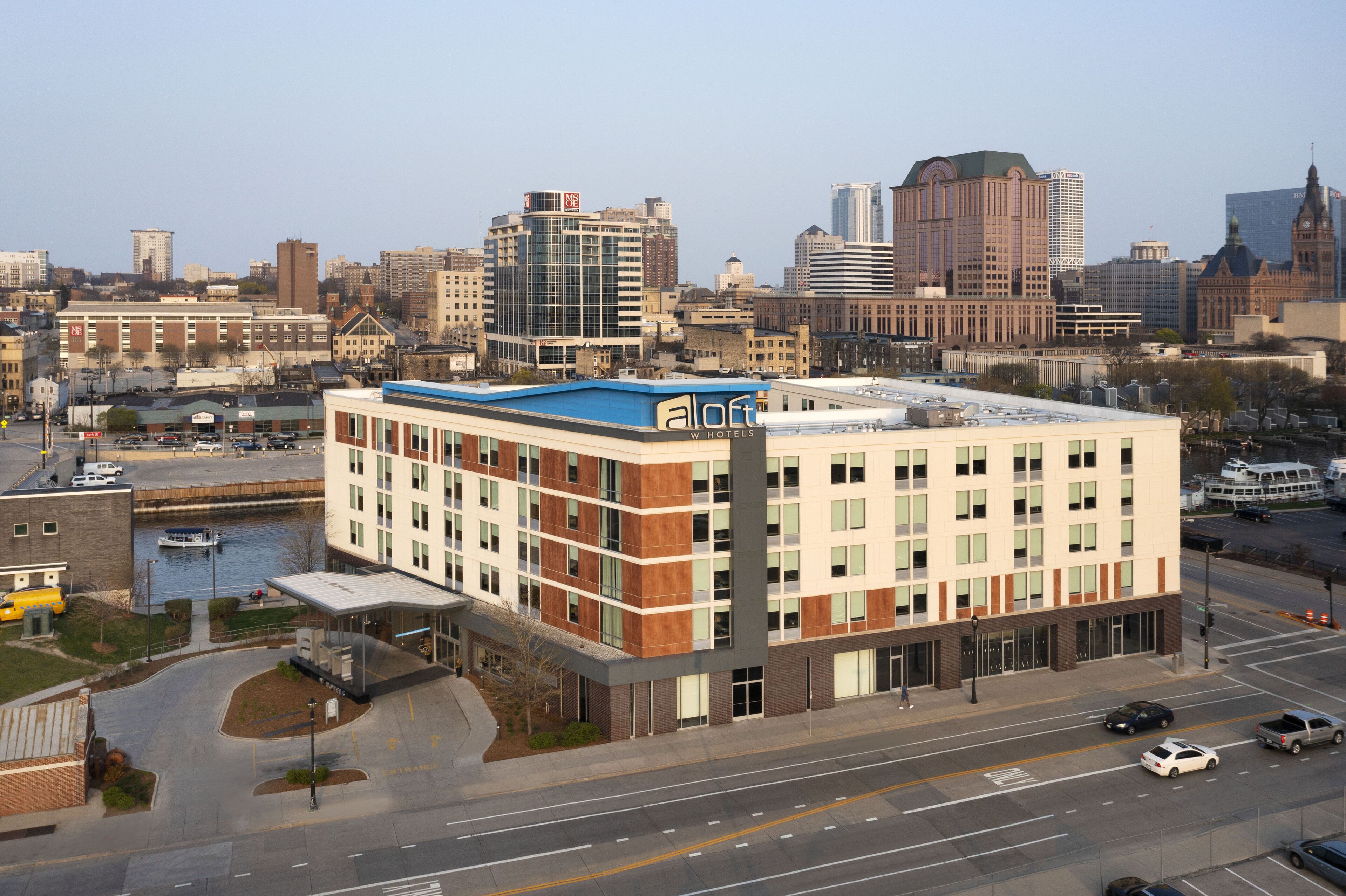 A modern hotel with a flat roof, multiple floors, and a prominent 'a loft' sign.