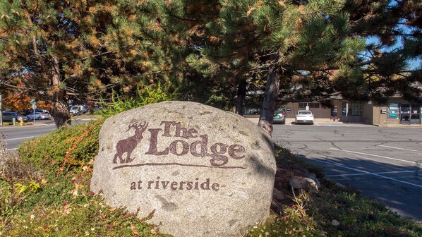 A stone sign with the text "The Lodge at Riverside" and a deer graphic.