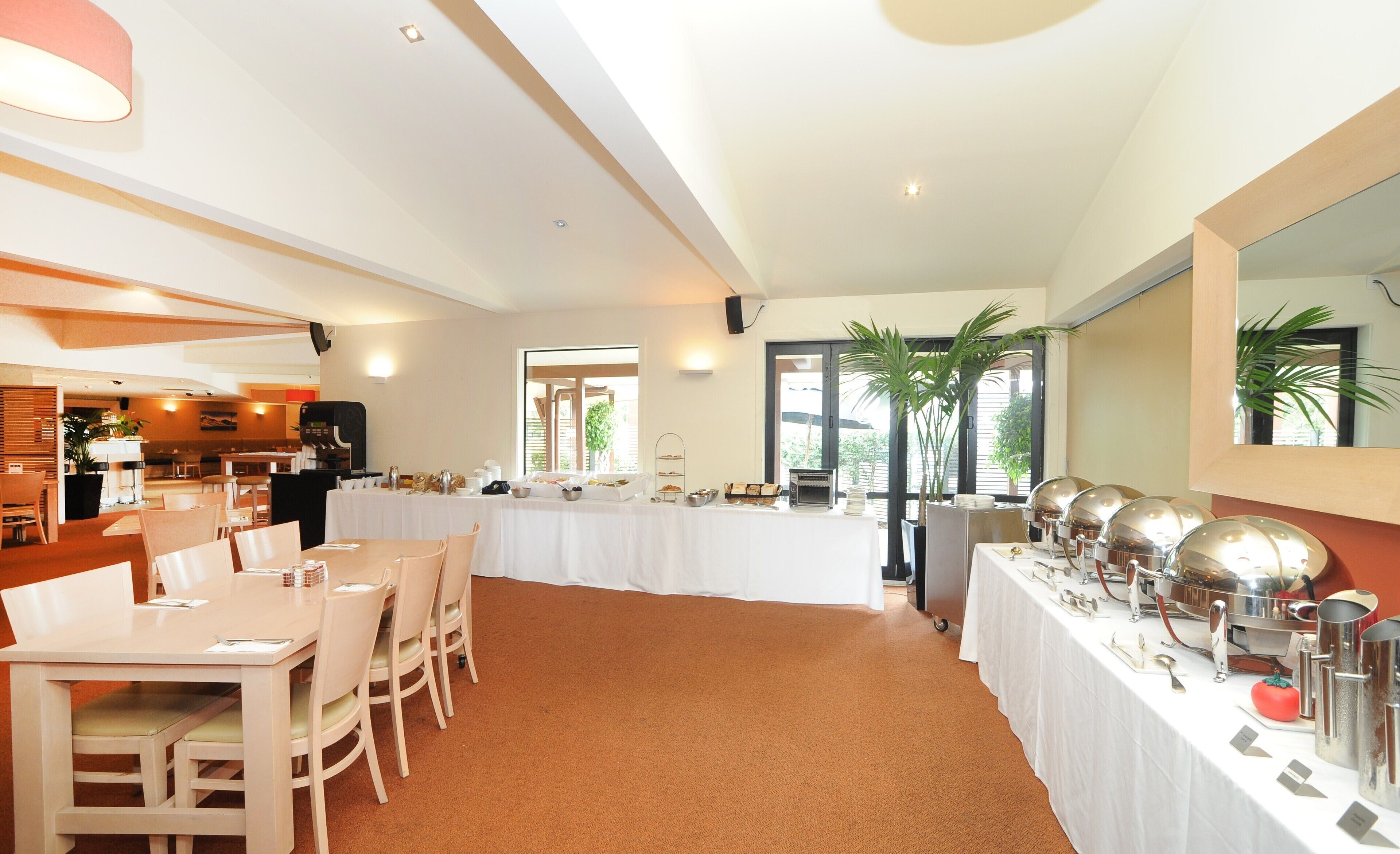 A dining area with a buffet setup, including a variety of food items and serving utensils.
