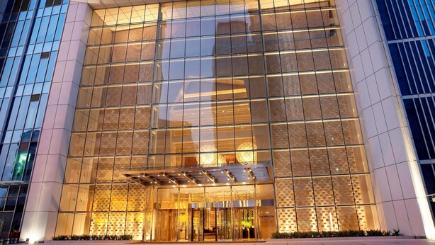 A modern hotel with a glass facade, a prominent entrance, and a well-lit lobby area. - The Westin Tianjin (Tianjin)