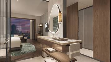 A modern hotel room with a large mirror, a vanity with a marble countertop, and a view of the cityscape.