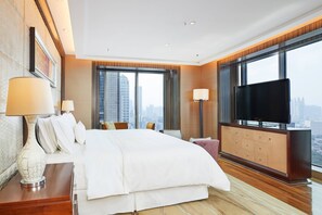 Habitación de hotel moderna con una cama grande, una televisión de pantalla plana y vistas a la ciudad.