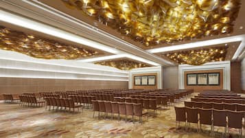 A conference room with rows of chairs, a patterned carpet, and a ceiling with a unique light fixture.