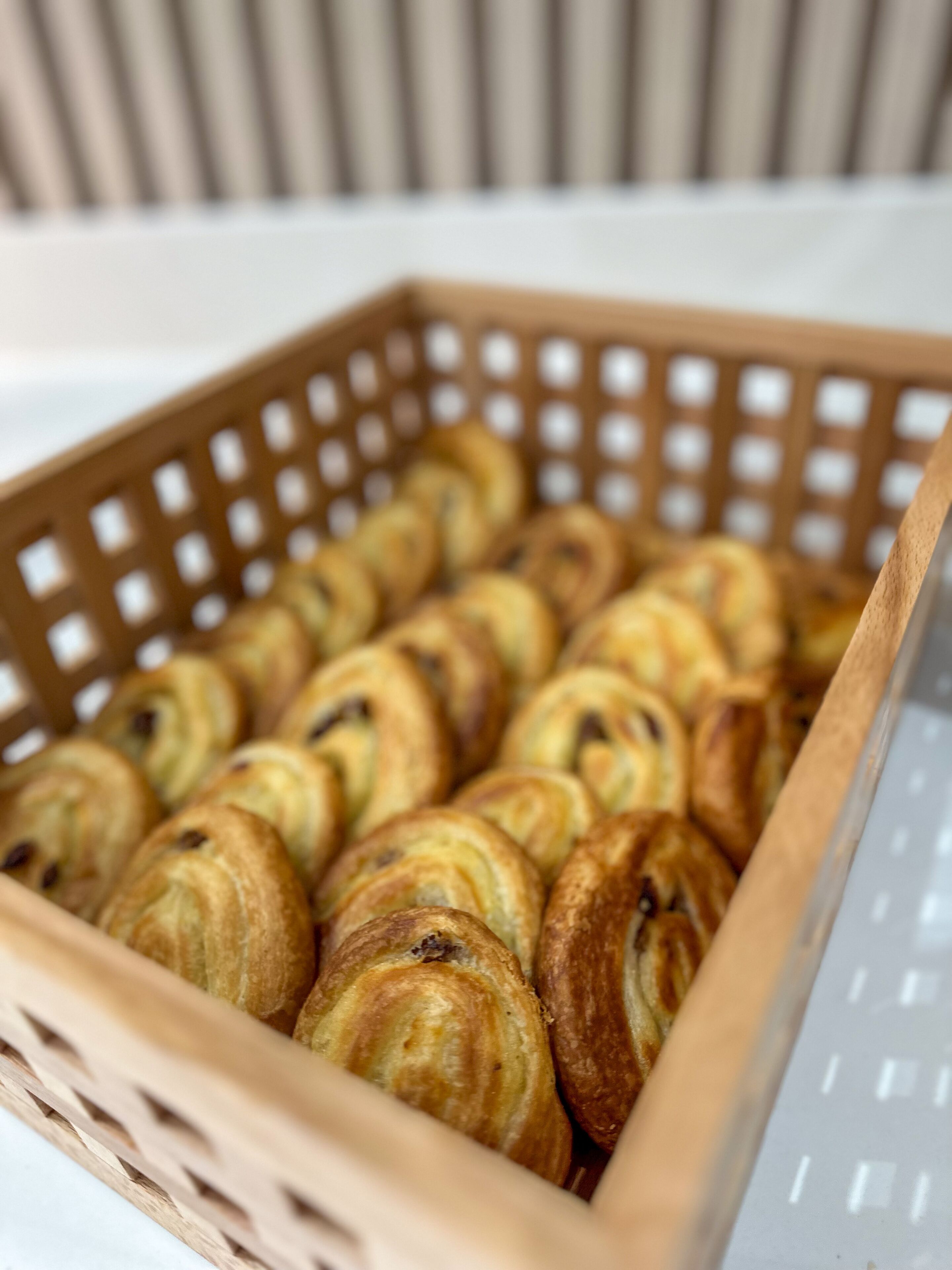 A wooden basket containing several pastries.