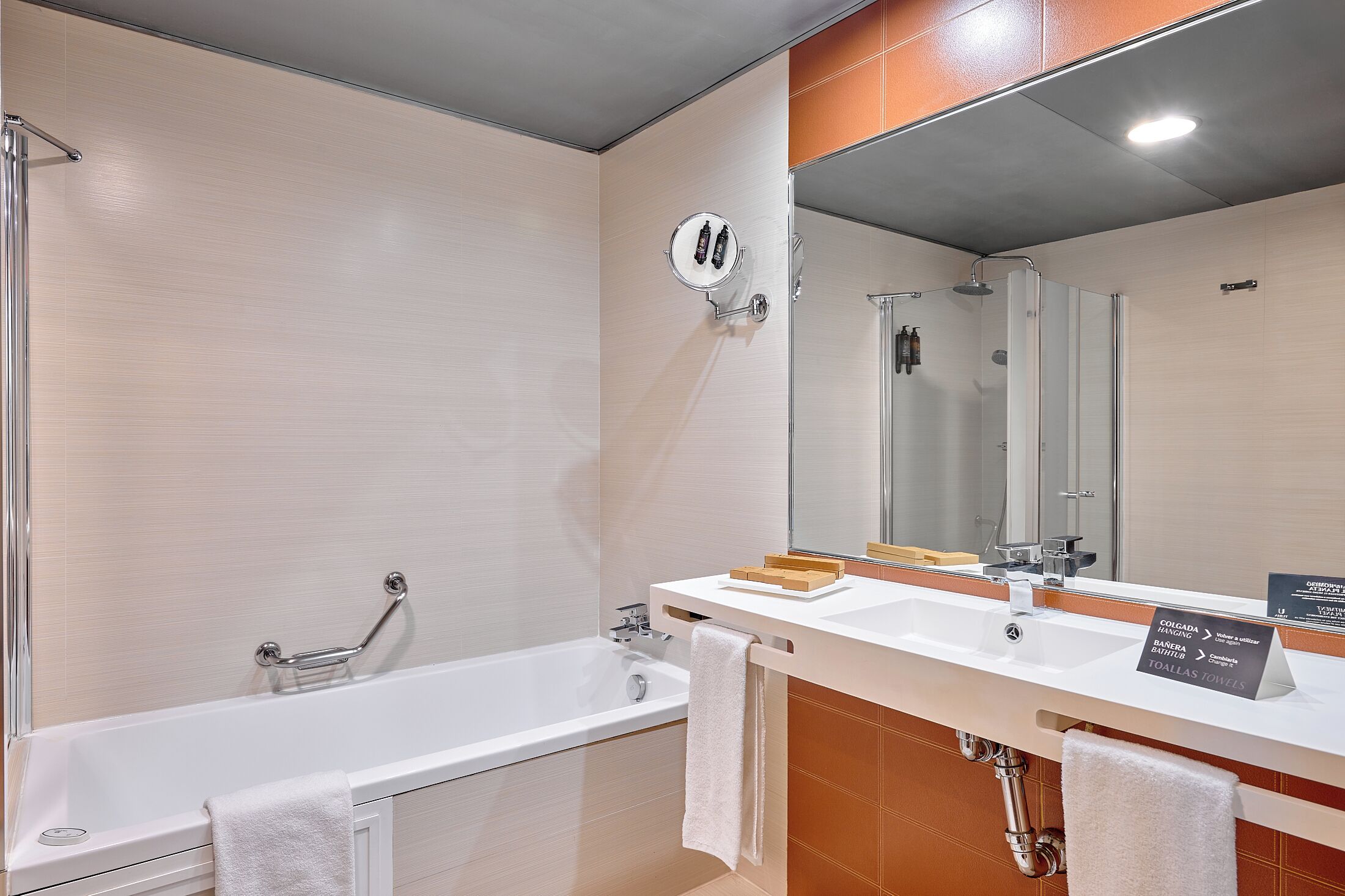 Un baño moderno con bañera, lavamanos y espejo.