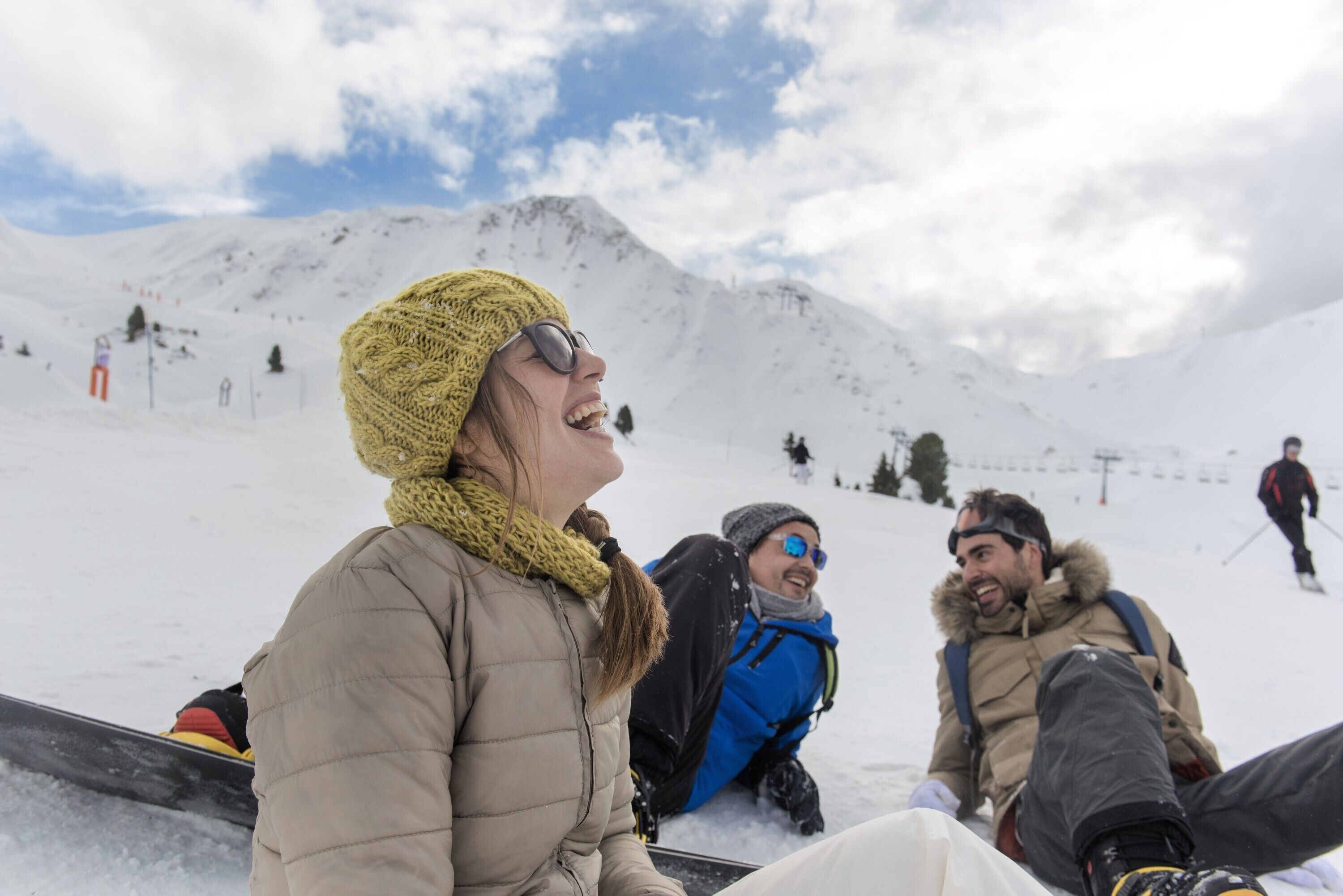 A group of people on a snowy slope with a clear sky.