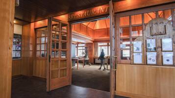A wooden interior with a sign reading 'RESTAURANT' and a person walking inside.