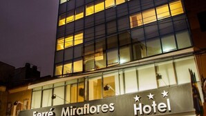Fachada de hotel con diseño moderno, destacando una entrada principal y señalización.