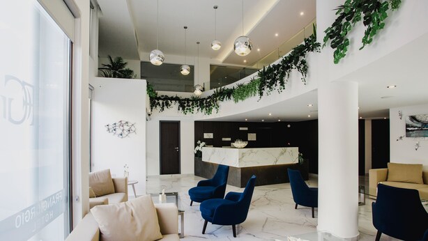 A modern lobby with a reception desk, seating area, and a glass coffee table.