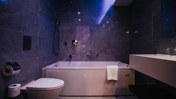 A modern bathroom with a bathtub, toilet, and sink.
