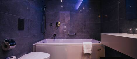 A modern bathroom with a bathtub, toilet, and sink.