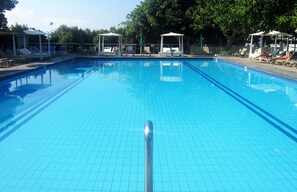 Una piscina al aire libre, tumbonas