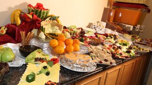 Un buffet proposant une variété de plats, notamment des fruits, des fromages et des salades.