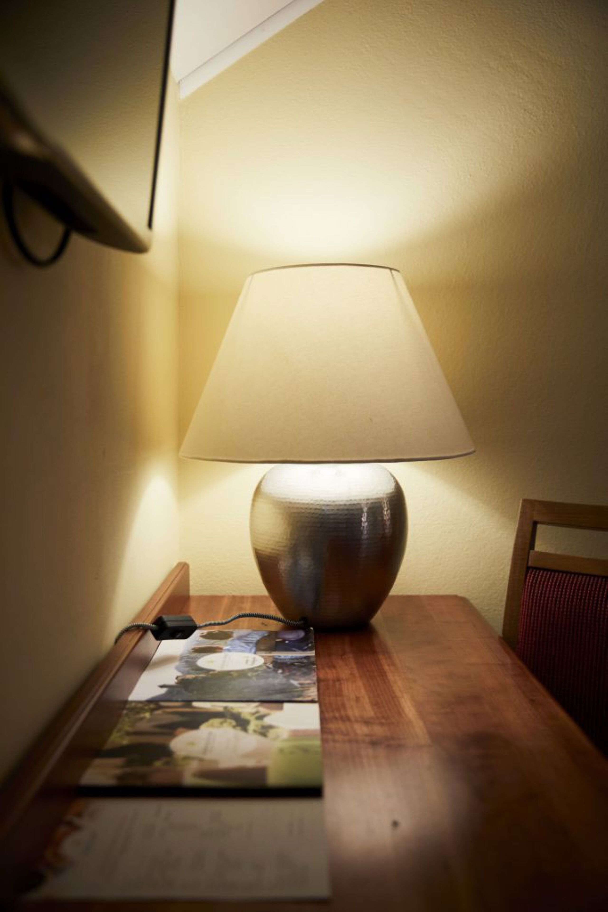 Una mesa con una lámpara y un libro.
