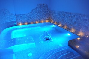 A hot tub with a stone wall and lights around the perimeter. - Hotel Livingston Siracusa (Syracuse)