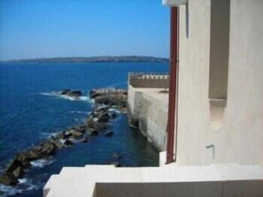 A coastal building with a view of the sea and a rocky shoreline. - Hotel Livingston Siracusa (Syracuse)