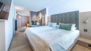 Ein modernes Schlafzimmer mit einem großen Bett, einem Nachttisch und einem an der Wand befestigten Fernseher.