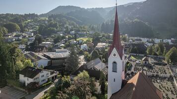 A church with a tall steeple, surrounded by residential buildings and a cemetery.