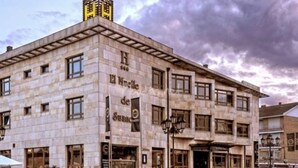 Un edificio histórico con numerosas ventanas y una entrada destacada.