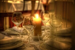 A table set with wine glasses, plates, and a candle, suggesting a dining area. - Hotel Spa El Muelle de Suances (Suances)