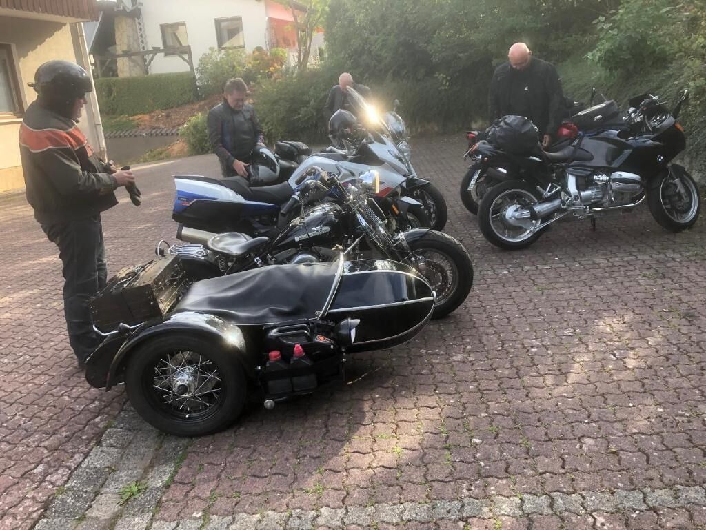 A group of motorcycles parked on a cobblestone surface.