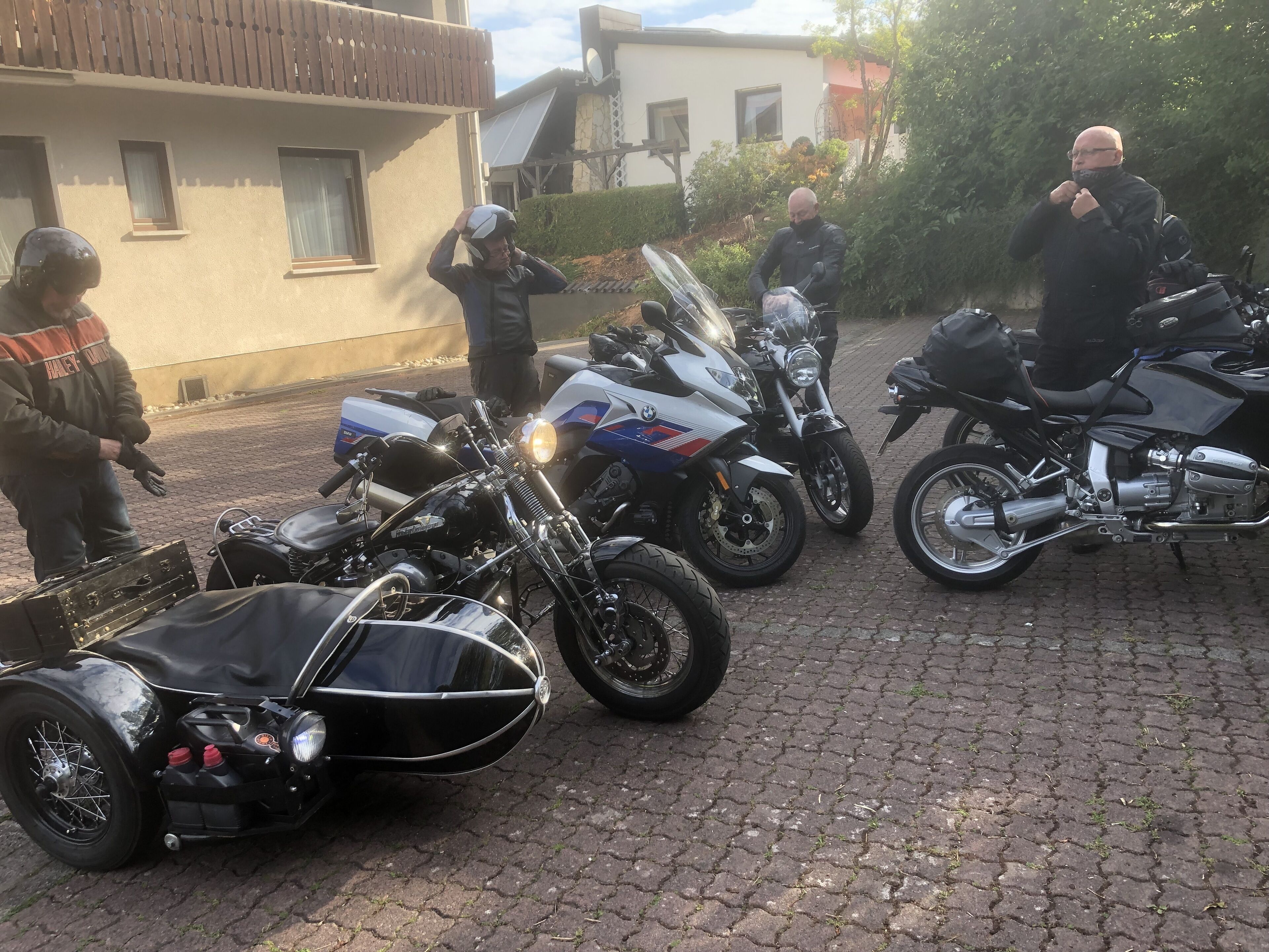 Eine Gruppe Motorräder auf einer Kopfsteinpflasterstraße.
