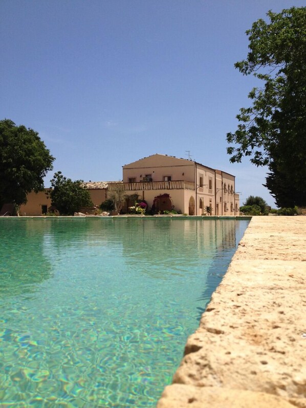 Een seizoensgebonden buitenzwembad, parasols voor strand/zwembad