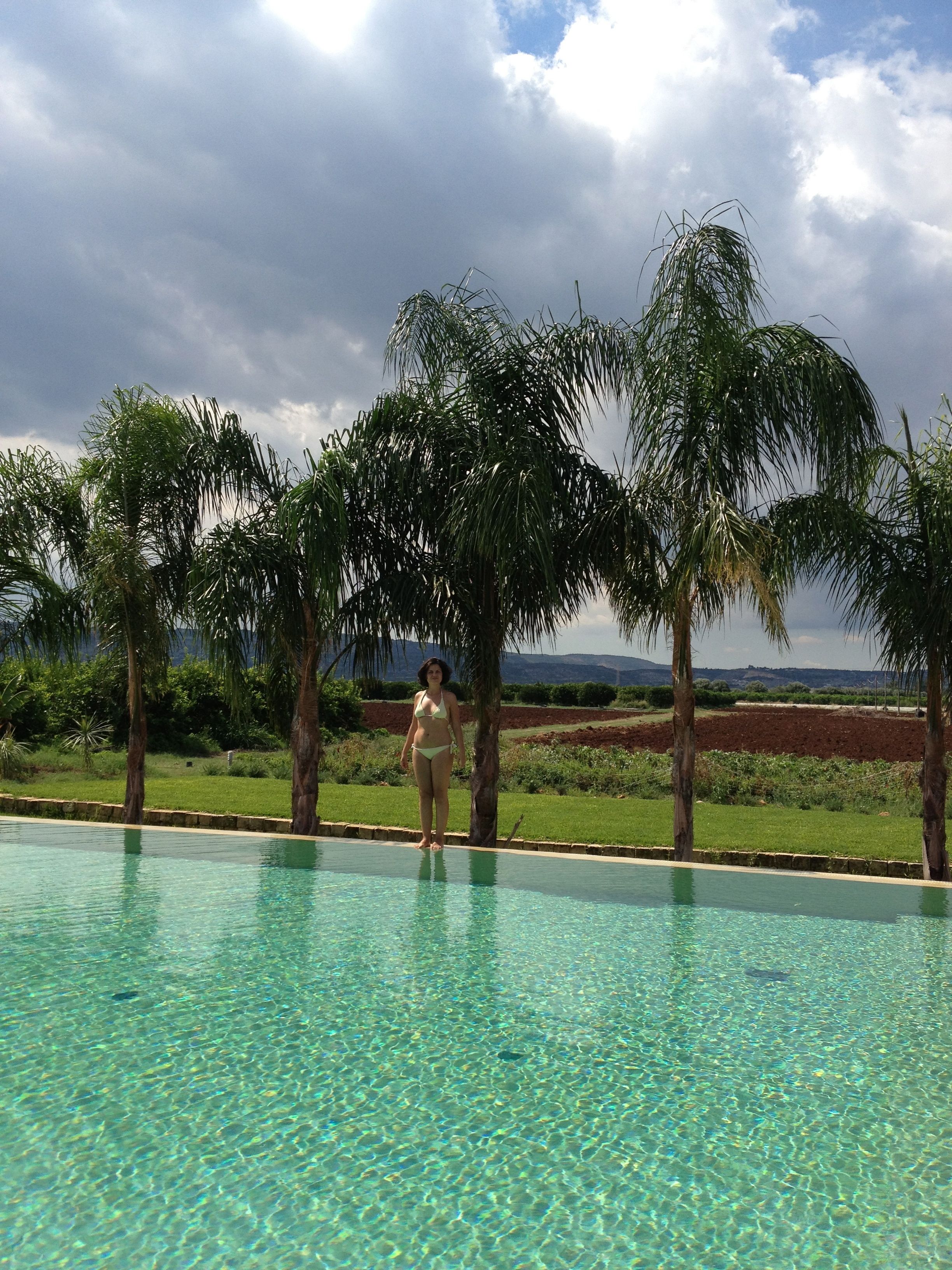 A clear swimming pool with a person standing at the edge.