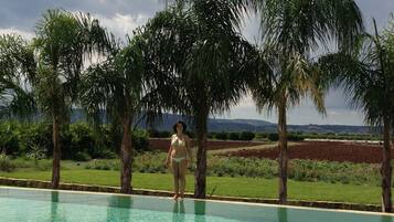 Una piscina cristalina con una persona de pie en el borde.