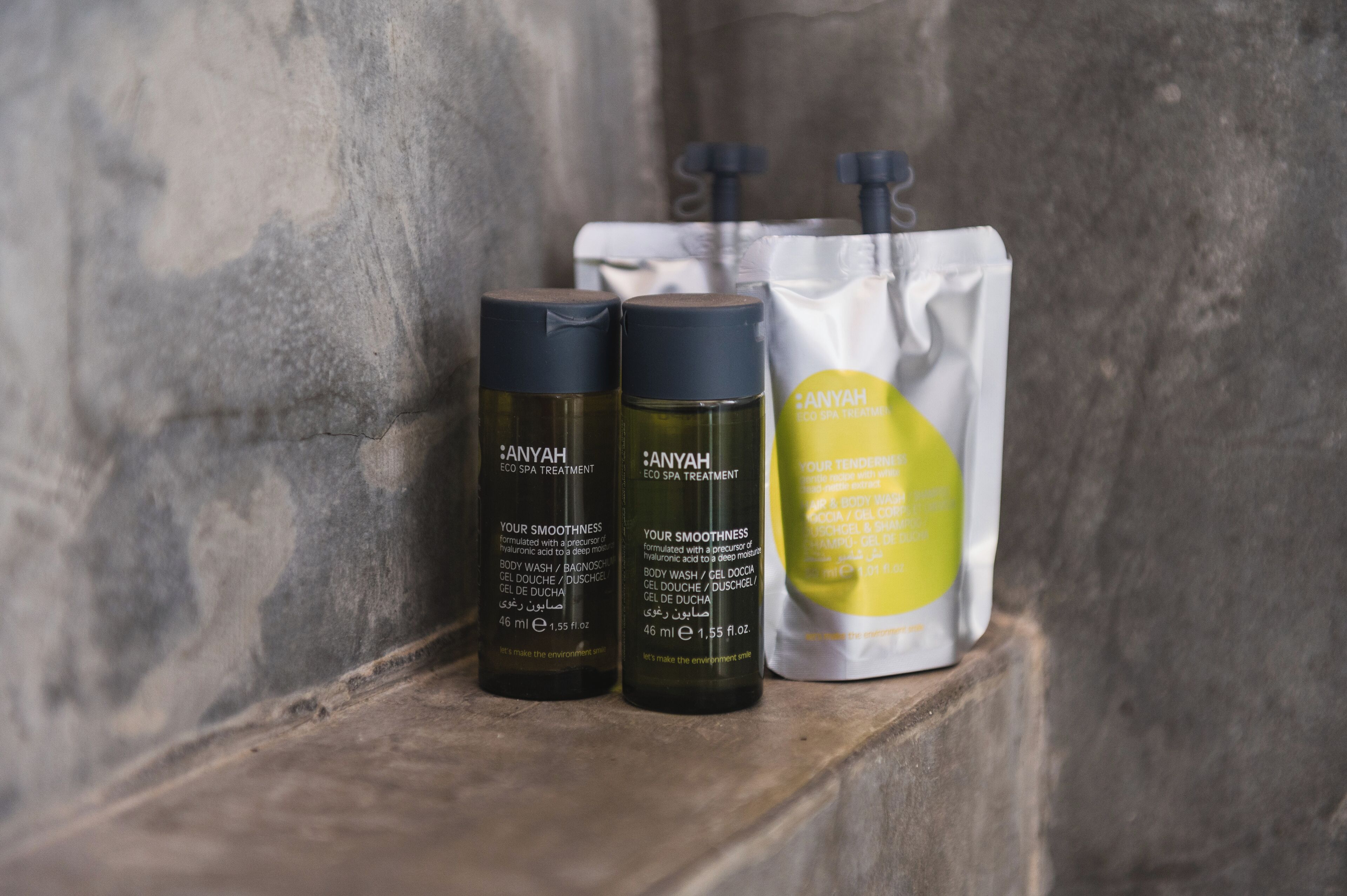 Tres botellas de tratamiento ecológico para spa Anyah sobre una estantería.